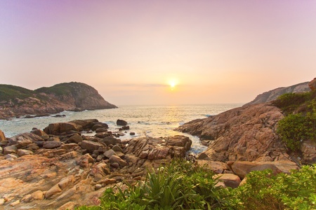 Sea rocks along the coast under sunriseの写真素材