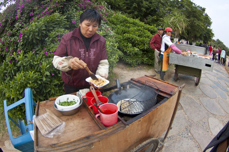 XIAMAN - JAN 2, Chinese lady selling tofu along the street in Xiamen, China on 2 January, 2012. のeditorial素材