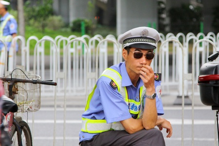 GUANGZHOU - APR 22, A policeman works along the street in Guangzhou, China on 22 April, 2011.のeditorial素材