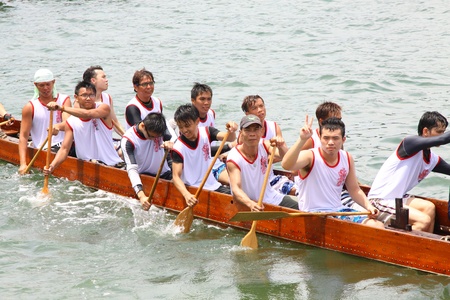 HONG KONG - JUN 6: Athletes fight hard for victory and they won at the dragon boat racing in Tuen Ng Festival 6, June 2011 in Tuen Mun, Hong Kong.のeditorial素材