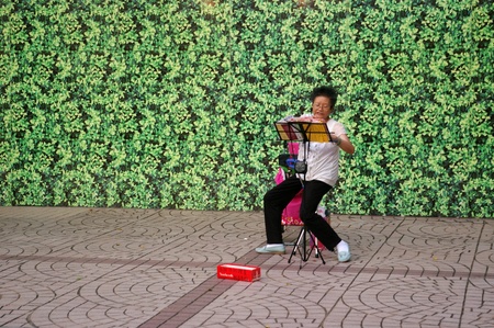 HONG KONG - AUG 22, A woman is singing along the street to earn money in Hong Kong on 22 August, 2010.のeditorial素材