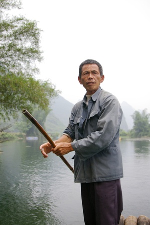 CHINA - MAY 16, A fisherman is paddling the bamboo boat along the Yulong River in Guilin, China on 15 May, 2010.のeditorial素材