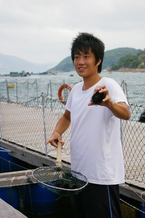 HONG KONG - SEPT 12, A young fisherman is introducing the fishing village to public on 12 September, 2009. のeditorial素材