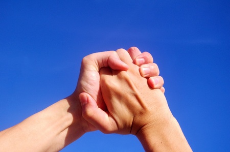 Holding hands under blue skyの写真素材
