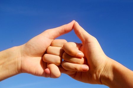 Holding hands under blue skyの写真素材