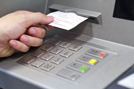 A hand taking a receipt of an Automated Teller Machineの写真素材