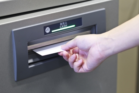 Taking money from ATM machineの写真素材