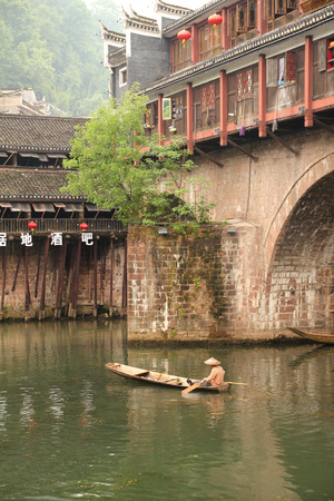 FENGHUANG - MAY 12: Wooden boat and wooden houses at tuojiang river in fenghuang ancient town on May 12, 2011 in Fenghuang, China.のeditorial素材