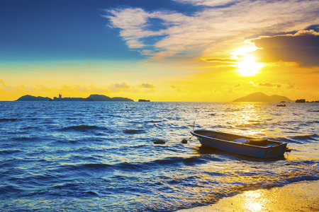 Boat on a sea coast at sunsetの写真素材