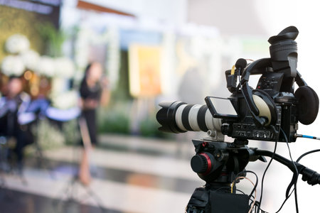 Covering an event on stage with a video camera.