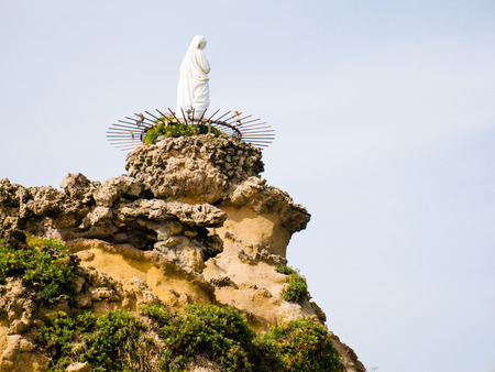 The statue of the Virgin Mary sits atop the rock formation at Rocher de la Vierge, Biarrtiz, Basque Countryの写真素材