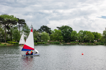 Landscape view of South Norwood lake where children can be seen pracitcing water sport activities such as sailingのeditorial素材