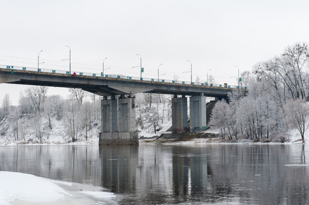 The bridge over the river and the forests is frozen.の写真素材