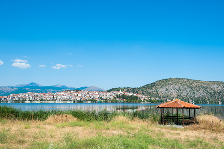 Arbor with an orange roof near the lake, on the background of the city.の写真素材