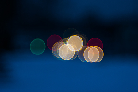 Colorful beautiful blurred bokeh background with copy space. Festive texture. Brilliant multicolored light spots on a dark blue background, defocused. Multicolored circles on a blue background.の写真素材