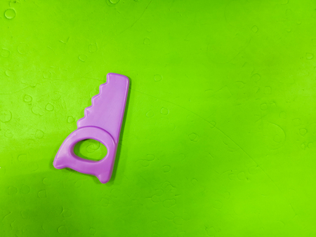 Children's saw, on a green background. Tool for the child, repairman detsky, development for children, preparing the child for adult lifeの写真素材