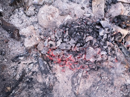 Close view at a glowing charcoal and flame in the barbecue grill. Shallow depth of field.の写真素材