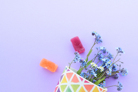 Flowers in a glass on a purple background. Fresh cut purple lilac flowers. colorful dishes, blooming flowers. Copy space.の写真素材