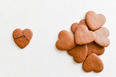 heart shaped cookies, one of them is broken on a white background. Crack heart-shaped cookies as a concept of unsuccessful relationships, unrequited love. Unrequited love concept .. Valentine's Day card. View from above.の写真素材