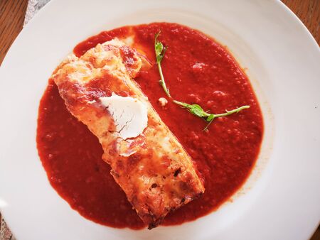 Lasagna in Tomato Sauce. Tasty delicious italian dish lasagna with tomato sauce and cream cheese with green salat. Food, tasty dinner concept.の写真素材