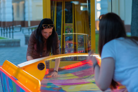 Girl fun playing slot machines. Children and adults play slot machines, attractions in the mall. Families with children have fun and play arcade games on computer machinesの写真素材