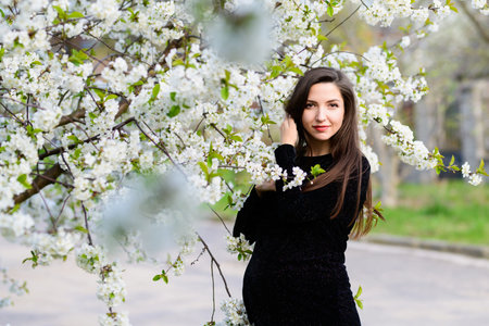 Pregnancy in the summer. Beautiful pregnant woman. Fashionable young parents, flowers and happiness...