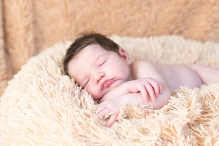 baby sleeps on a blanket. Sleeping newborn boy on a beige blanket.の写真素材