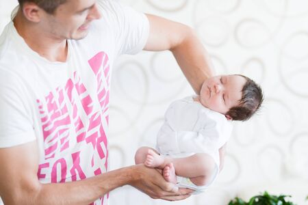Sleeping baby in her arms. Father holding her newborn baby daughter after birth on arms., Concept of love and family., Newborn baby boy., New lifeの写真素材