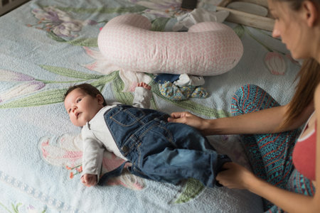 mother dresses the child. Mom dresses her little boy. collects the baby for a walk.の写真素材