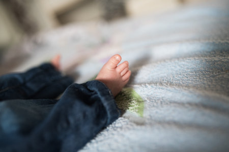 Little baby leg. Cute little baby crawling on white bed sheet, closeup. Space for text.