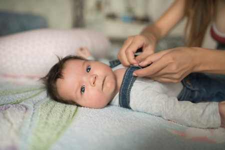 mother dresses the child. Mom dresses her little boy. collects the baby for a walk.