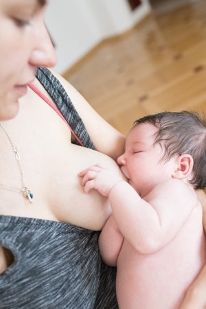 the mother is breastfeeding the baby. mother breastfeeds and hugs the baby, close-up breast. Mom...