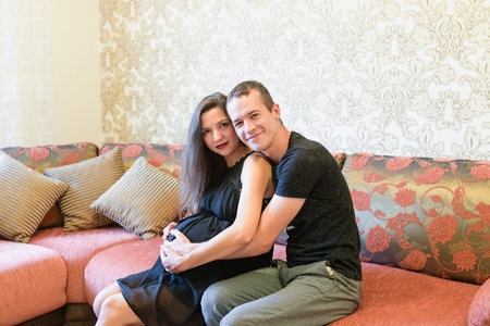 Happy couple expecting a baby. Happy family lifestyle. Young couple are expecting a baby. Pregnant...