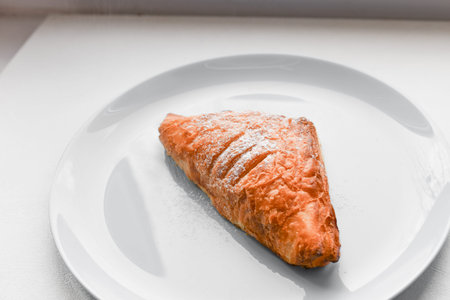 Kurasan on a blue plate. Breakfast with curasan and coffee in a white table. on a blue plate. with...