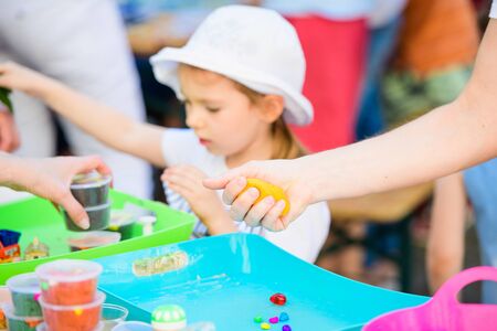 child sculpts figures from plasticine. development center. help children with disabilities. A pretty girl of three years old sits at the table and sculpts figures from colored clay. Sculpting and childrens creativityのeditorial素材