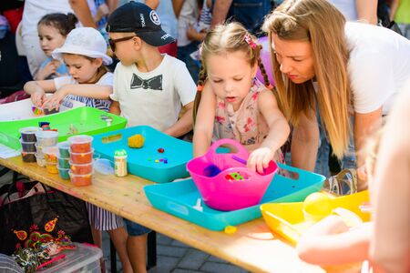 child sculpts figures from plasticine. development center. help children with disabilities. A pretty girl of three years old sits at the table and sculpts figures from colored clay. Sculpting and childrens creativityのeditorial素材