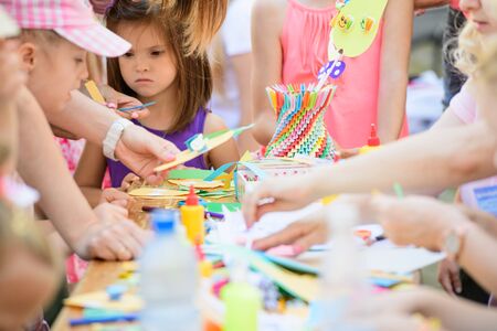 MOSCOW, RUSSIA - April 24, 2019: children and adults at the table do needlework and paint on the street on a sunny day. children's Day. developing club for children with disabilitiesのeditorial素材