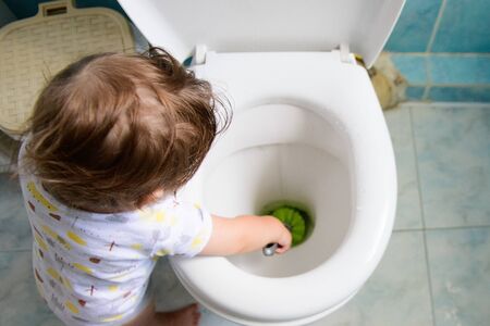baby and cleaning. help mom with cleaning. toilet and baby. training the child to use the toiletの写真素材