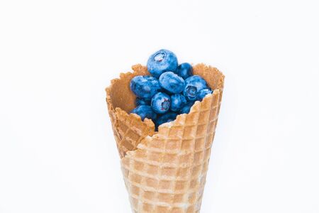 Berry ice cream. Blueberry in a horn. On a background for an inscription. hand and ice cream. top view vitamins concept. place for an inscription. berry love conceptの写真素材