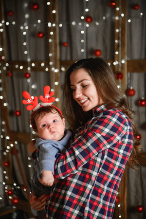 Baby with mother at Christmas. happy family mother and baby little son playing home on Christmas...