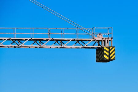 construction crane counterweight. High building construction site. Big industrial tower crane with blue sky amd cityscape on background. Concrete plates weight balance. Counterweight. Aerial drone view. Metropolis city development. .の写真素材