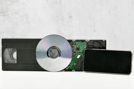 the evolution of the film. change of media. video cassette, disk, hard drive. close-up. place to write. The evolution of storage technology and media. Concept collage.の写真素材