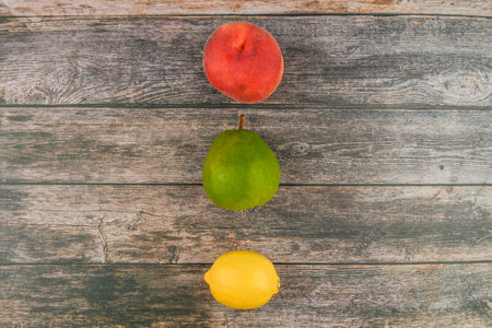 Peach, pear, lemon on a wooden background. Wooden blocks with the words Vitamin C, fresh fruits in...
