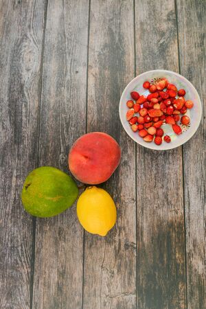 Peach, pear, lemon on a wooden background. Wooden blocks with the words Vitamin C, fresh fruits in the background, healthy food or diet concept. View from above. Place for writingの写真素材