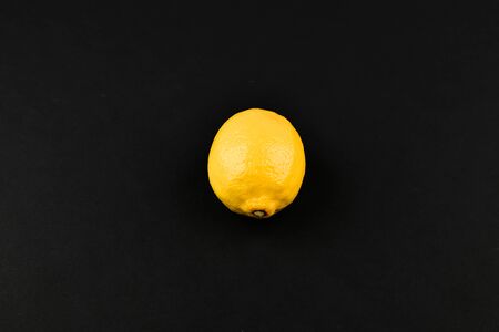 Lemon on a black background. Fresh juicy lemon on a black background. View from above. A place to write. In isolation. Cut out the background.の写真素材