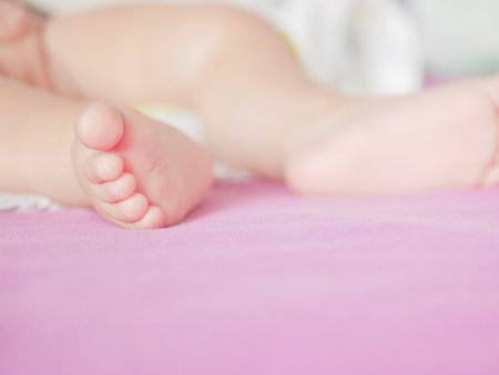 Children's feet. Looks from a knitted pastel blanket. Close-up. A place to write. Placing text....