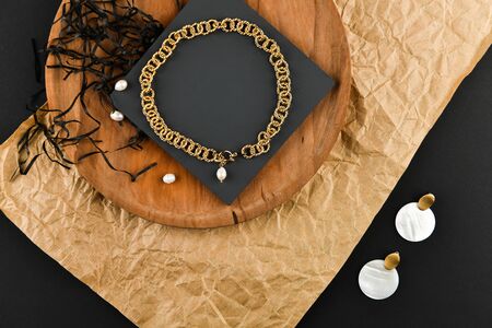 Gold earrings with a necklace. Close-up. Laid out on a wooden stand. View from above. The concept of jewelry and jewelry. Gifts for women. shopping. Handworkの写真素材