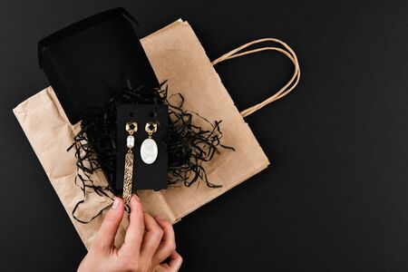 Gold earrings. asymmetry. Close-up. Laid out on a wooden stand. View from above. The concept of jewelry and jewelry. Gifts for women. shopping. Handworkの写真素材