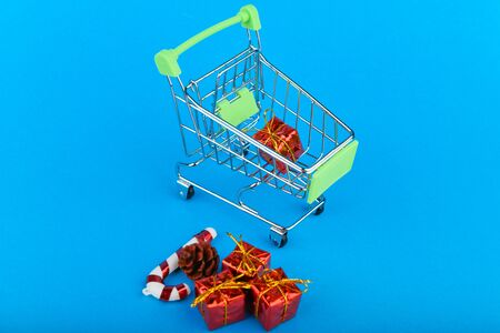 Christmas presents shopping concept. Basket and christmas accessories. Christmas basket with presents. Onlain shopping. On a blue background. place for writingの写真素材