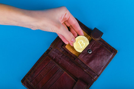Bitcoin theft concept. A hand steals bitcoin from a wallet. Place for writing